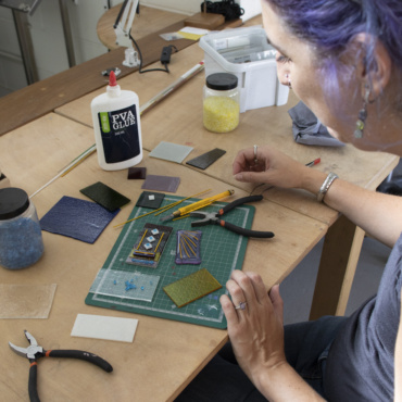 a woman in a fused glass course working at her craft bench